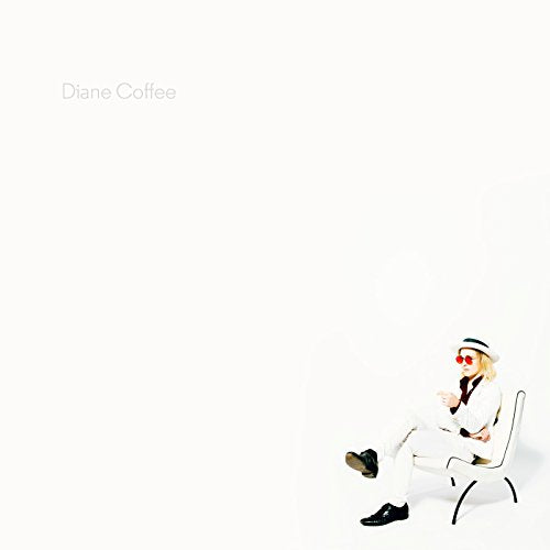 Album cover: person in white suit and hat sits in a chair.