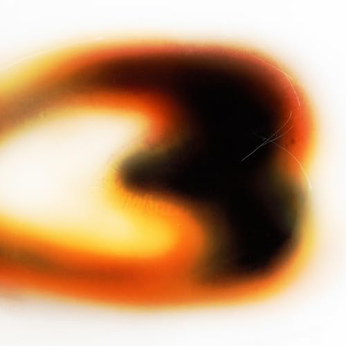 Abstract blurred shape with orange, yellow, and black colors on a white background.