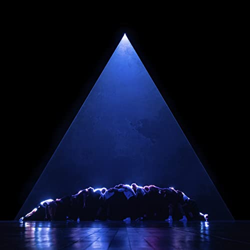 Group of people in suits forming a circle under a blue triangle.
