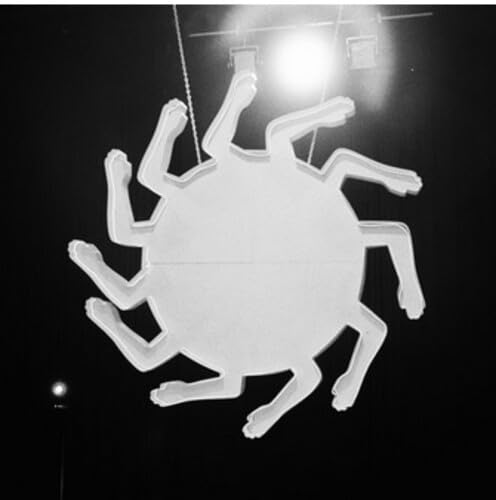 Black and white image of a circular neon sign with radiating arms.