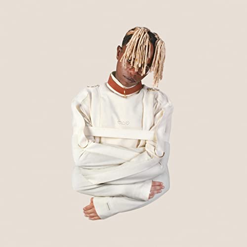 Person with blonde dreadlocks wearing a white straightjacket, looking down.