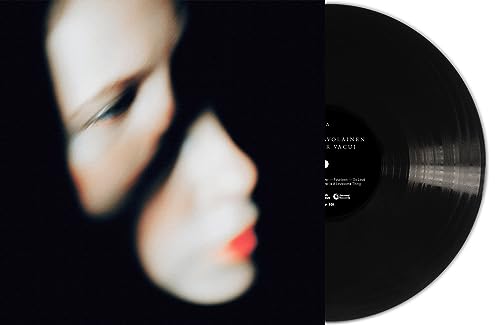 Vinyl record with a portrait of a woman in shadow, black background.