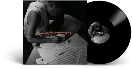 Vinyl record and album cover featuring a man writing music.