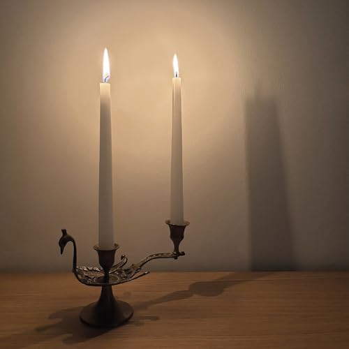 Two lit white taper candles in an ornate metal candelabra.