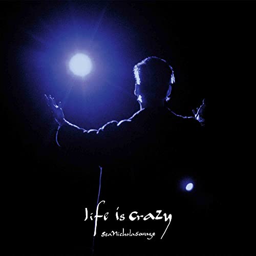 Silhouette of a man with arms raised under a bright light, album cover.