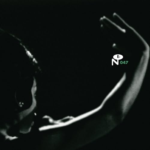 Black and white close-up of a person with raised arms against a dark background.