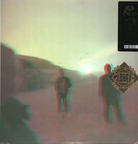 Vinyl record cover with blurred figures and a sunset landscape.