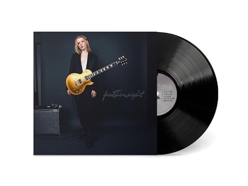 Vinyl record with album cover featuring a woman holding a guitar.