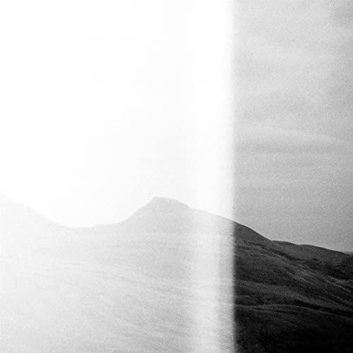 Black and white album cover with blurred mountain landscape.