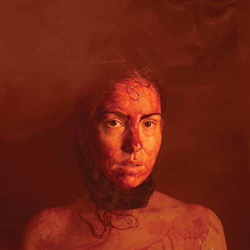 Close-up portrait of a woman with red markings on her face and neck.