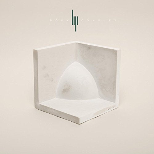 White geometric sculpture in a corner, with text above.