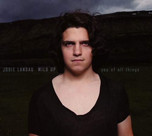CD cover featuring a portrait of a man with curly hair, stormy background.