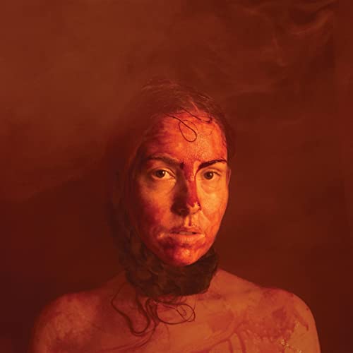 Close-up portrait of a woman with red markings on her face and neck.