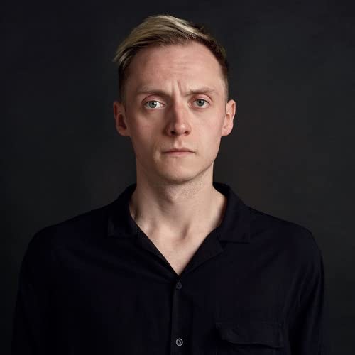 Portrait of Hamish Hawk, a man with pale blonde hair and dark clothing.