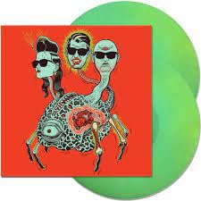 Puscifer album cover with three figures and a green vinyl record.