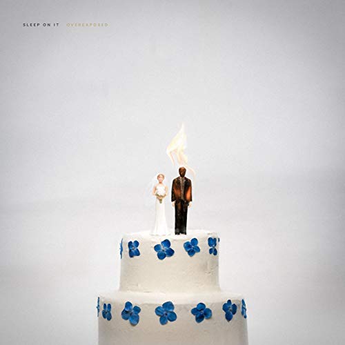 CD cover: wedding cake with miniature figures and a burning candle.