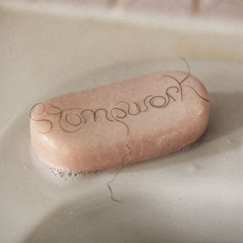 Pink soap bar with the word "Stumpwork" written in dark hair strands.