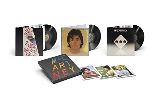 Three vinyl records with covers and a box set with accompanying photo cards.