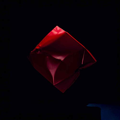 Red, crumpled paper shape against a dark background.
