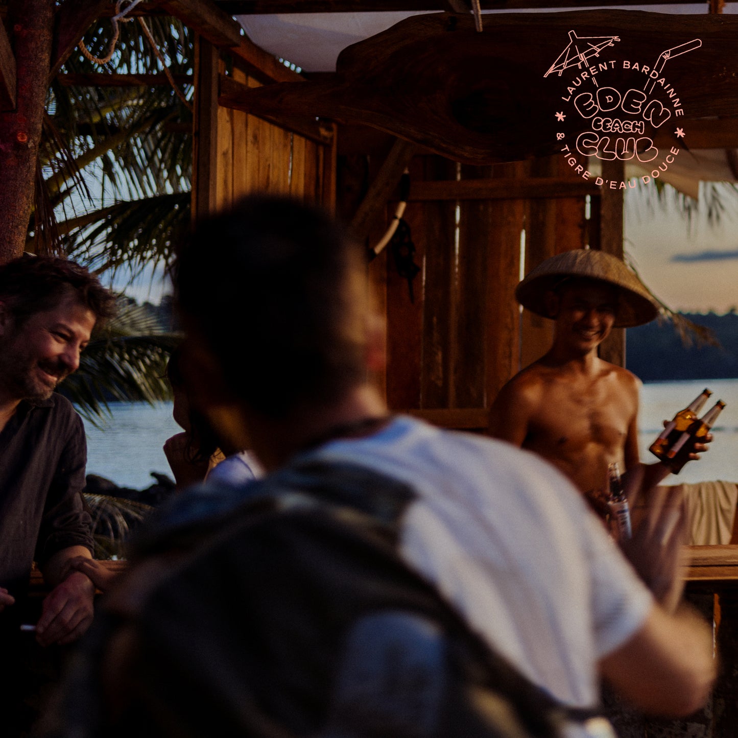 CD cover featuring people relaxing at a beachside wooden structure.