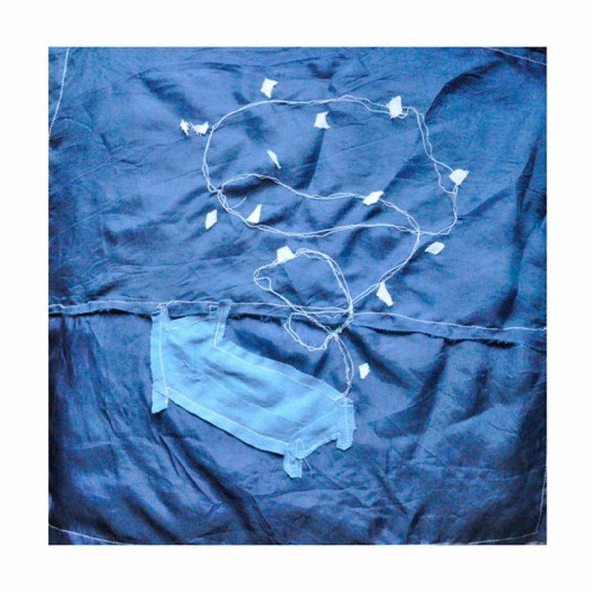 Blue cyanotype image with string lights and a face mask outline.