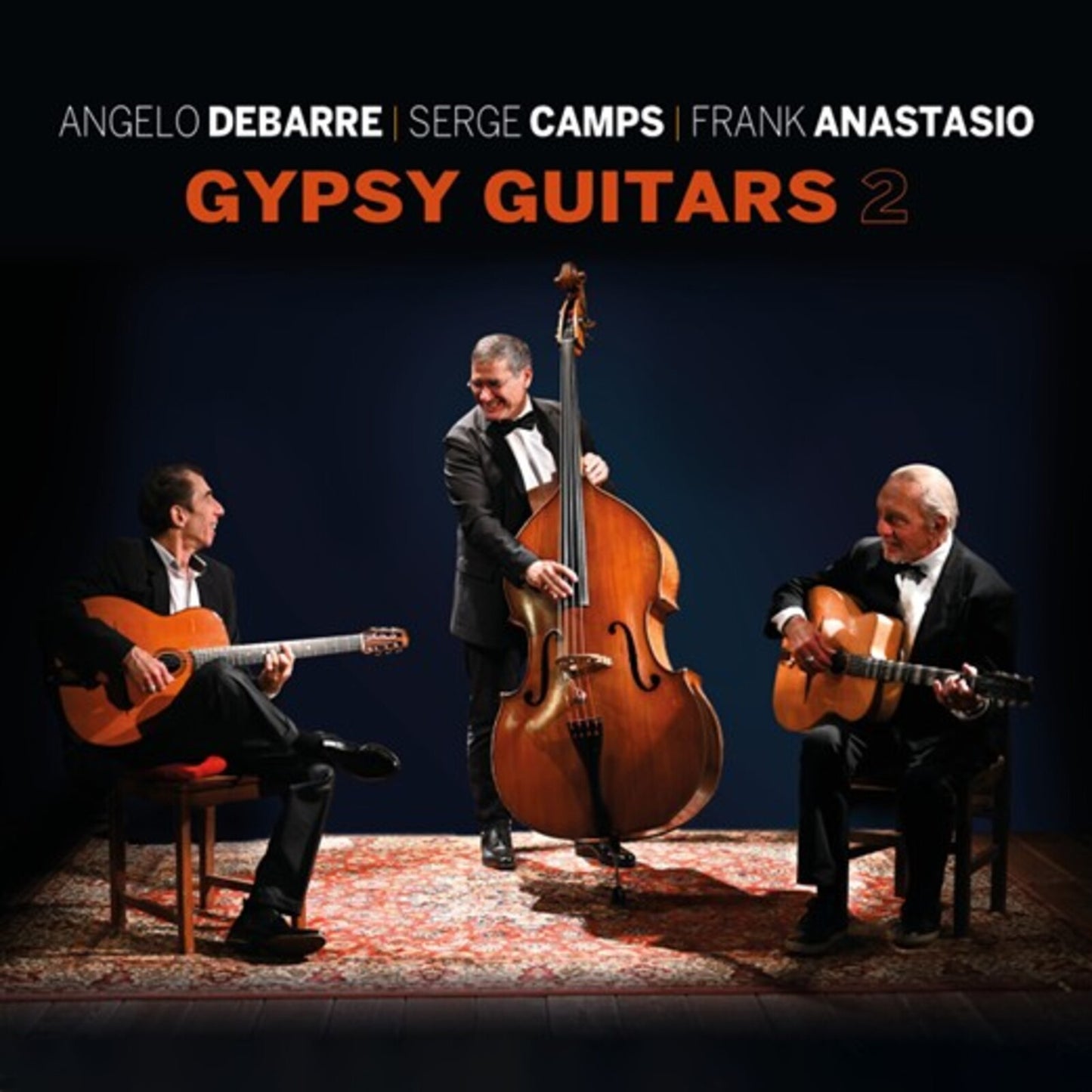 Three musicians with guitars and a double bass on stage.