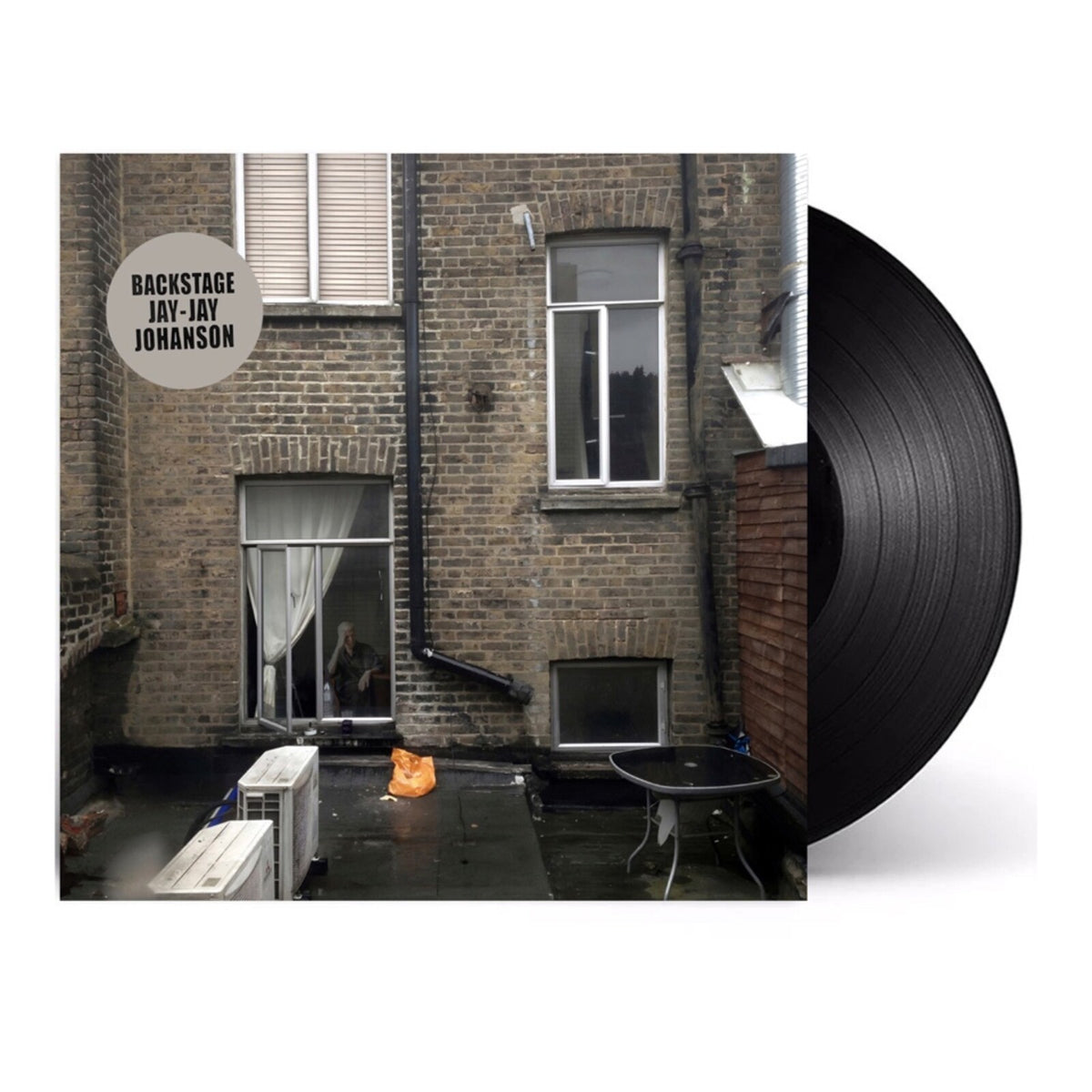 Vinyl record with album cover showing a brick building and windows.