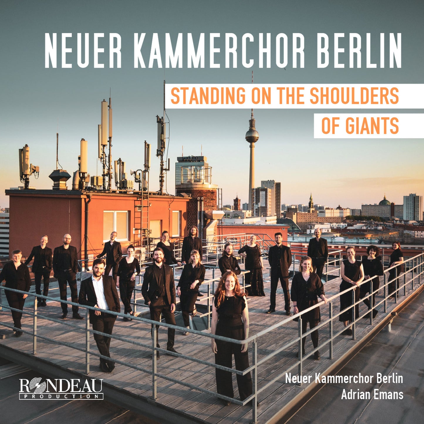 Choir group on a rooftop with Berlin skyline in the background.