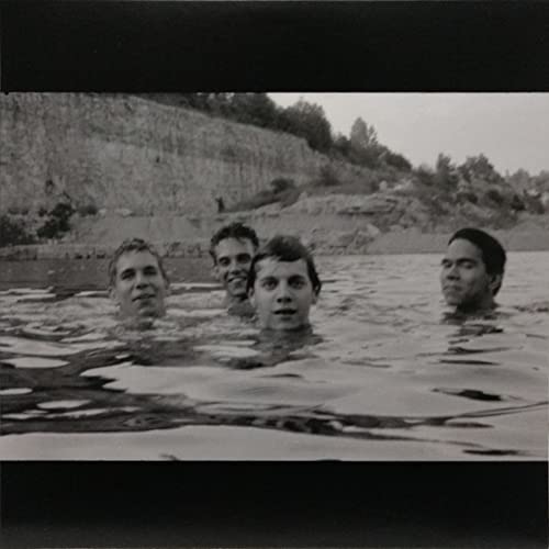 Black and white photo of four men partially submerged in water.