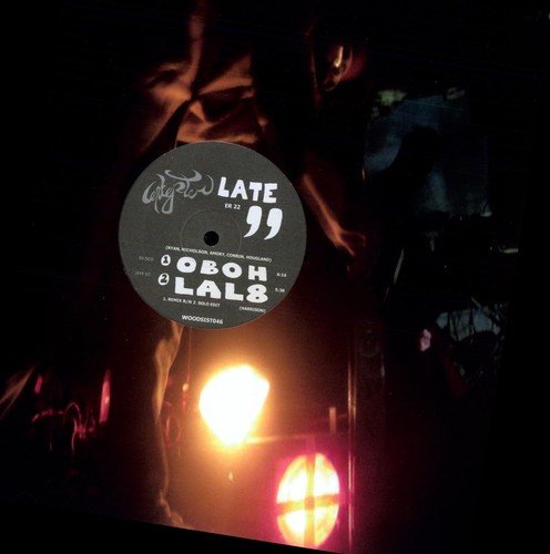 Black vinyl record with white label reading “LATE” and artist details.