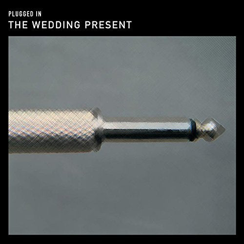 Close-up of a guitar plug on a gray and black album cover.