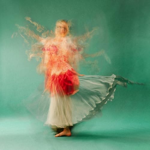 Woman in flowing red and white dress, motion blur, teal background.