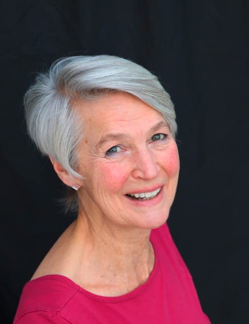 Close-up portrait of a smiling woman with short grey hair.