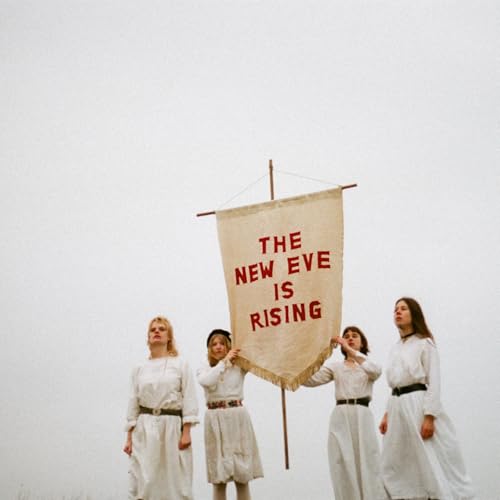 Four people hold a banner reading "The New Eve Is Rising" outdoors.