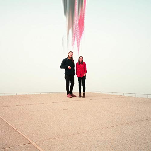 Two people stand on a concrete surface with distorted red streaks above.