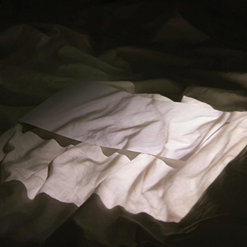 Dark, abstract image of crumpled white fabric on a shadowed surface.