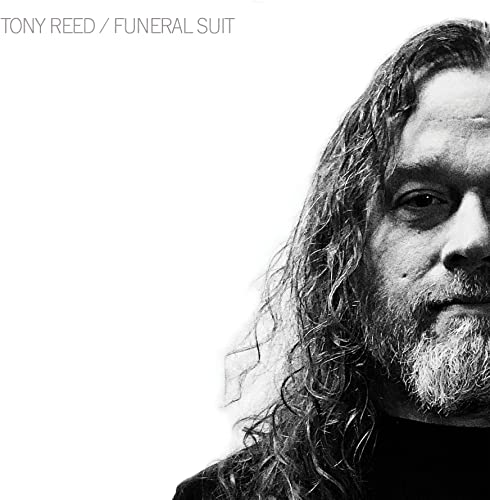 Black and white portrait of Tony Reed with long hair and beard.