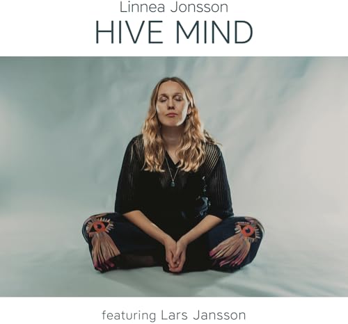 Woman with closed eyes seated in lotus position, album cover.