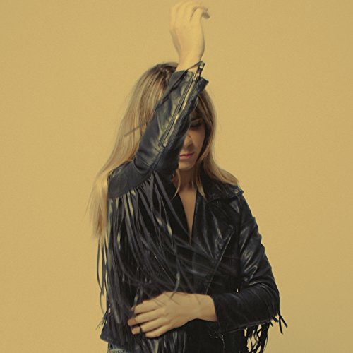 Woman with long blonde hair partially obscured by a black fringed jacket.