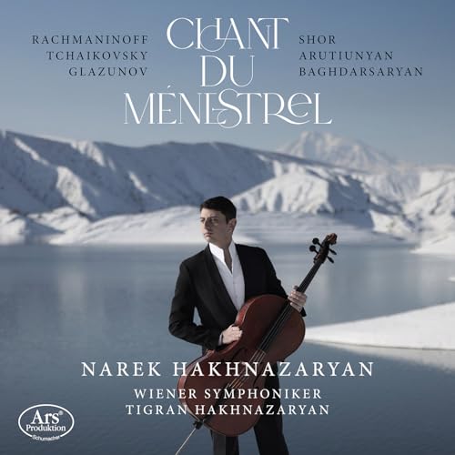 Cellist Narek Hakhnazaryan stands with his instrument against a snowy mountain backdrop.