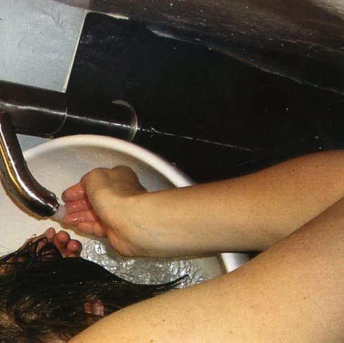 Person receiving a hair wash at a salon sink.