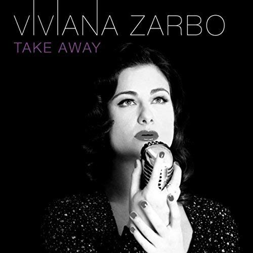 Black and white portrait of a woman singing into a vintage microphone.