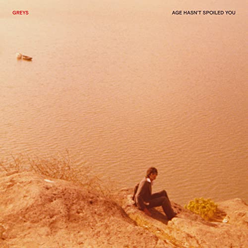 CD cover: person sitting by water, orange and brown tones.