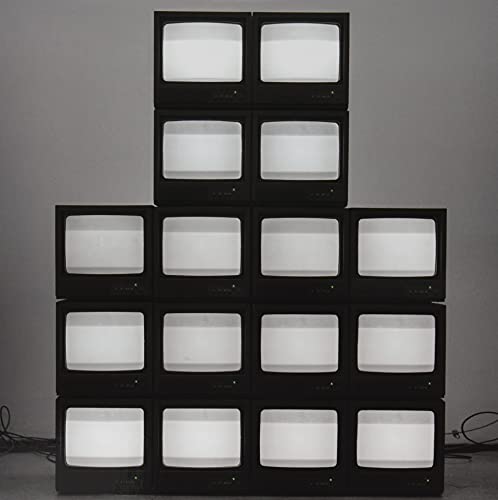 Pyramid of vintage televisions with glowing white screens.