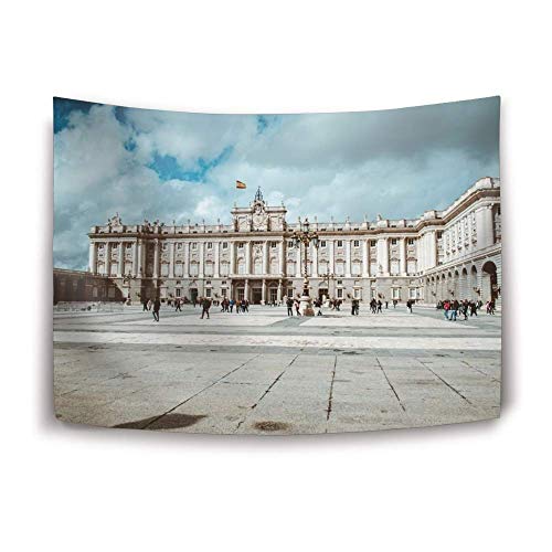 Royal Palace of Madrid exterior with cloudy sky and people.