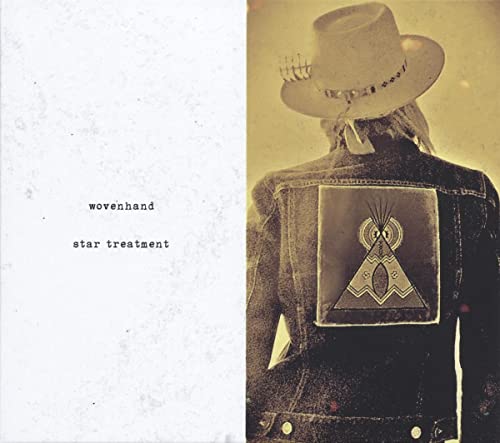 A person in a cowboy hat and denim jacket with a teepee patch on back.