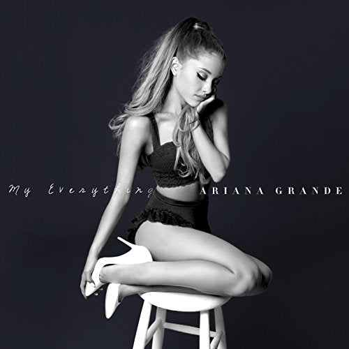 Ariana Grande sits on a white stool in a black and white album cover.