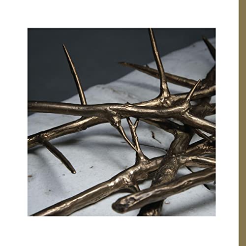 Close-up of metallicCinterC tangled, metallic gold-colored branches with sharp thorns.