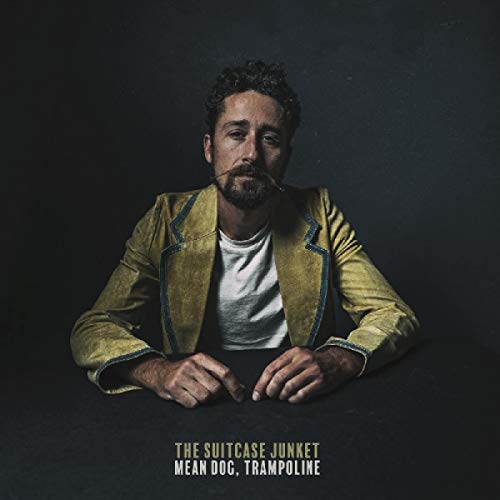 Man in yellow jacket smoking, album cover for The Suitcase Junket.