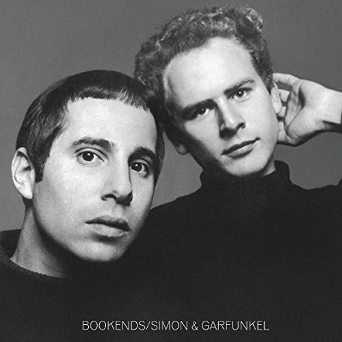 Black and white portrait of Paul Simon and Art Garfunkel wearing black turtlenecks.